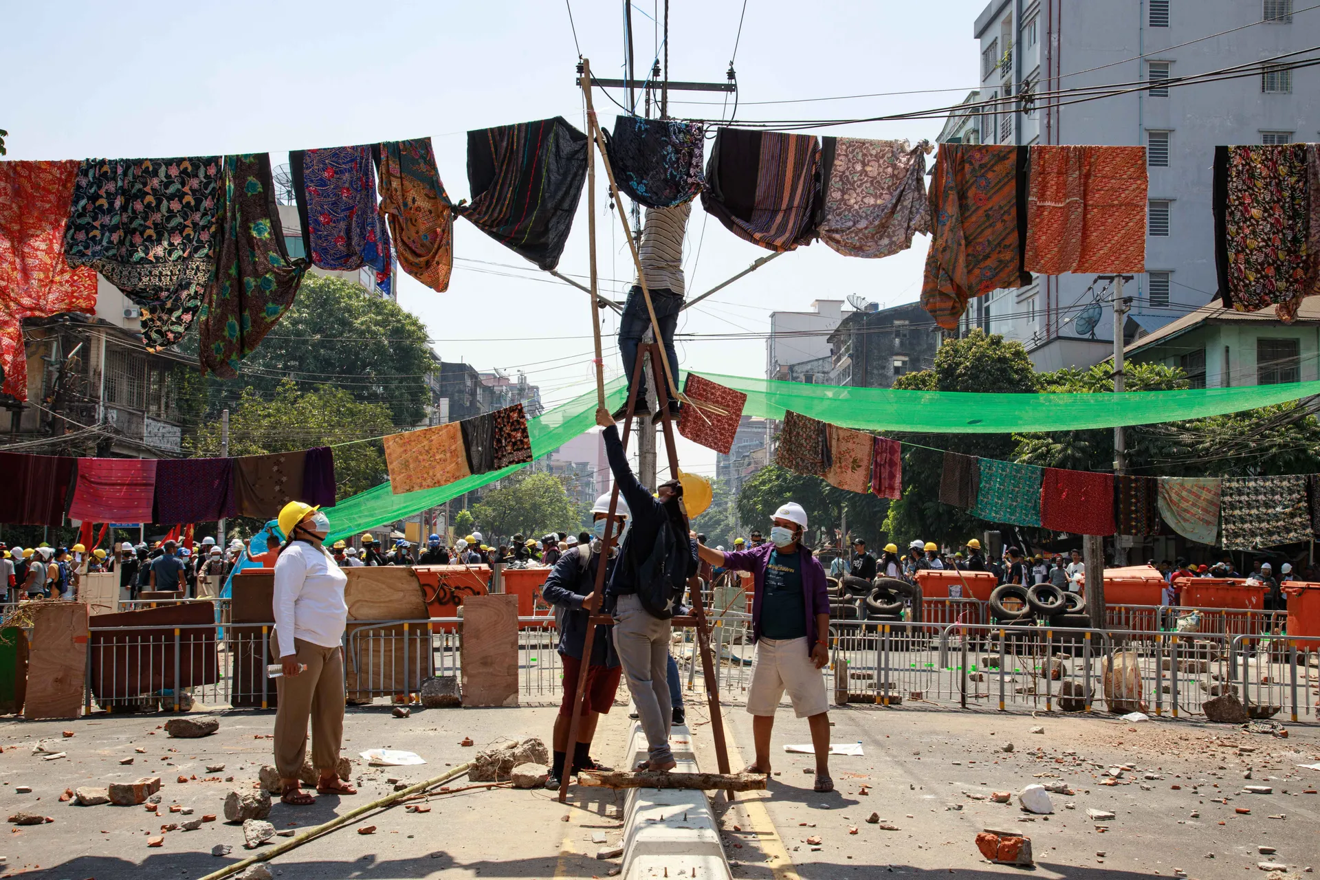 Protestors hanging women's longyi (gowen) up in the air with ropes as soldiers believe in superstition that being under women's longyi could bring back luck or could die during war.Photo - TaMwe